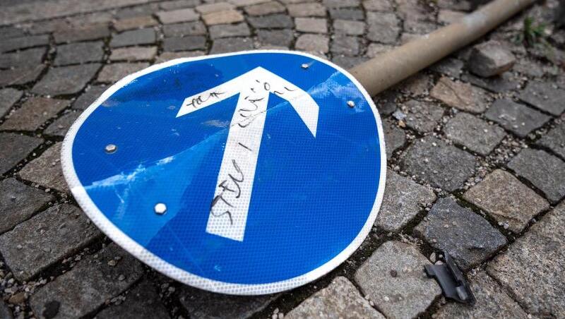 Ein beschädigtes Verkehrsschild liegt auf einer Verkehrsinsel. (Symbolbild)