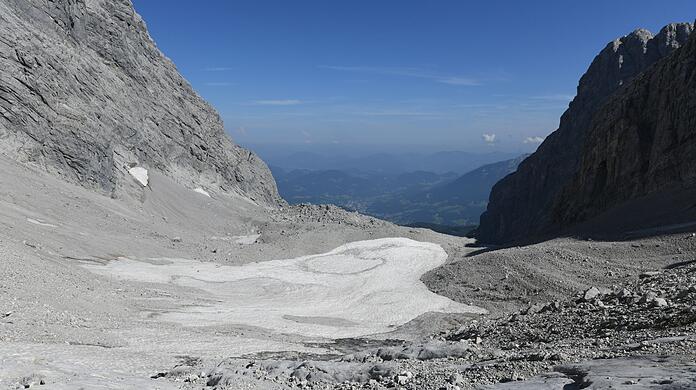 Altschnee und Geröll liegen auf dem kleinen Überrest des Watzmanngletschers.