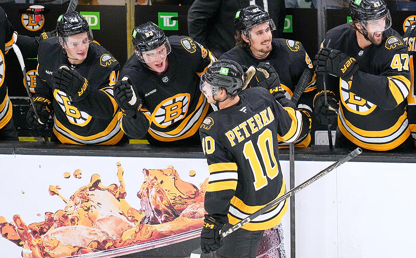 JJ Peterka holt sich nach seinem ersten Tor für die Boston Bruins an der Bande seine Glückwünsche ab. JJ Peterka holt sich nach seinem ersten Tor für die Boston Bruins an der Bande seine Glückwünsche ab.