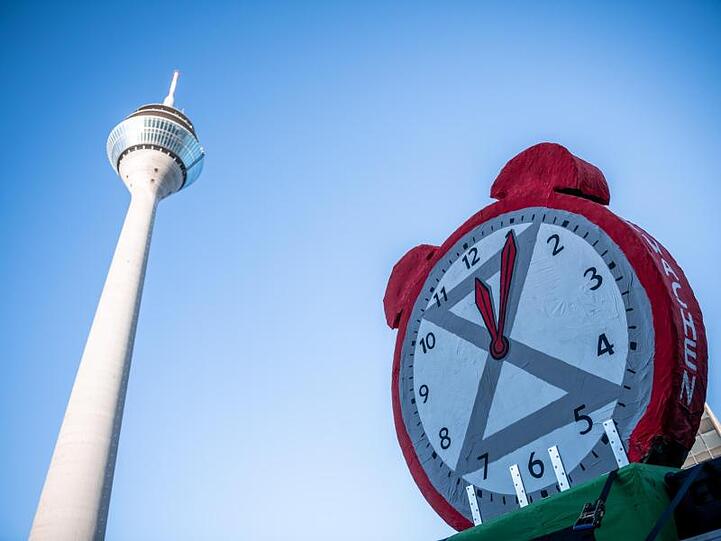 Fünf nach zwölf zeigt ein Wecker auf der Demonstration in Düsseldorf.
