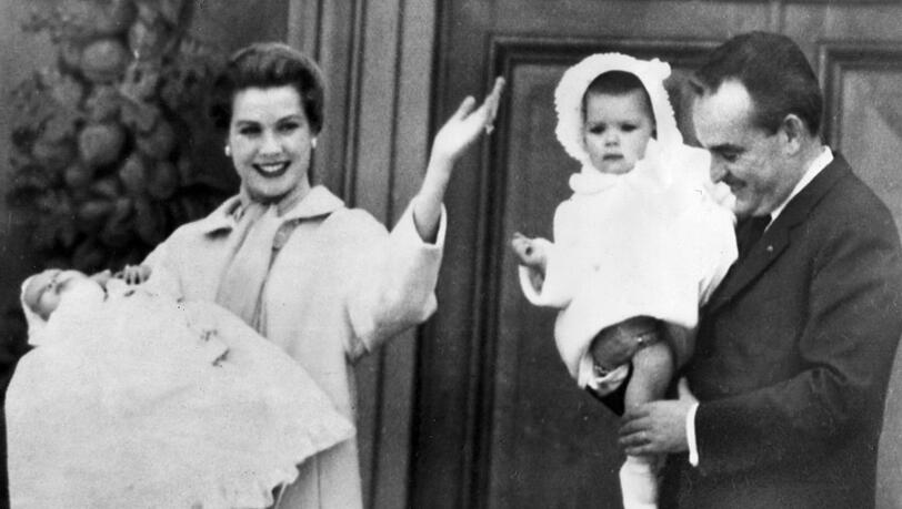 Fürstin Gracia Patricia winkt von einem Balkon mit ihrem Sohn Prinz Albert auf dem Arm der monegassischen Bevölkerung zu, rechts trägt ihr Gatte Fürst Rainier III. von Monaco Töchterchen Prinzessin Caroline. Fürstin Gracia Patricia winkt von einem Balkon mit ihrem Sohn Prinz Albert auf dem Arm der monegassischen Bevölkerung zu, rechts trägt ihr Gatte Fürst Rainier III. von Monaco Töchterchen Prinzessin Caroline.