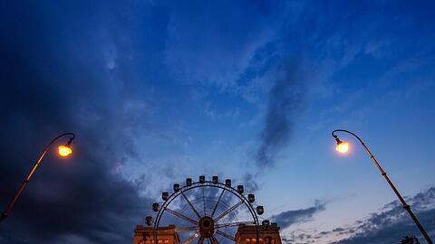 Ein Riesenrad steht am späten Abend auf dem Königsplatz vor der Kulisse der Propyläen. Foto: Peter Kneffel/dpa/Archivbild