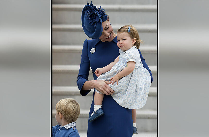 Gewohnt stilvoll: Kate in einem blauen Kleid von ihrer Lieblings-Designerinnen Jenny Packham. Ein besonderes Detail: Ihre Brosche erinnert an das Motiv einer typischen, kanadischen Münze.