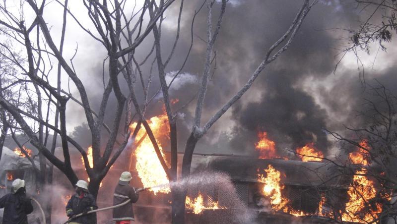 Feuerwehrleute versuchen den Brand des umgestürzten Tanklasters zu löschen. Feuerwehrleute versuchen den Brand des umgestürzten Tanklasters zu löschen.