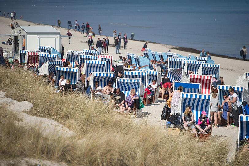 Das frühlingshafte Wetter nutzen auch Touristen zum Sonnenbad im Strandkorb am Strand des Ostseebades Binz auf der Insel Rügen.