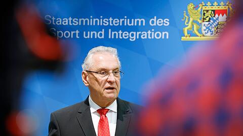 Bayerns Innenminister Joachim Herrmann (r, CSU) spricht in einer Pressekonferenz.