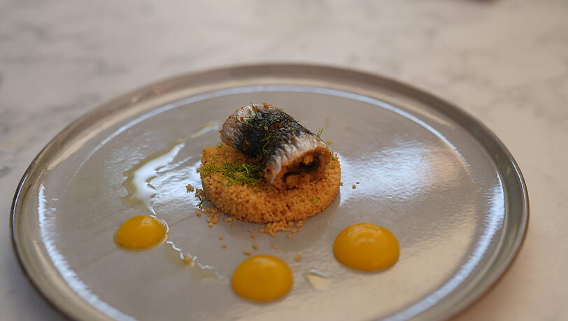 Sarde a Beccafico: Sizilianische Sardine, Pinienkerne, Rosinen, Orangen-Brot, Cajun Couscous, Clementine. Sarde a Beccafico: Sizilianische Sardine, Pinienkerne, Rosinen, Orangen-Brot, Cajun Couscous, Clementine.