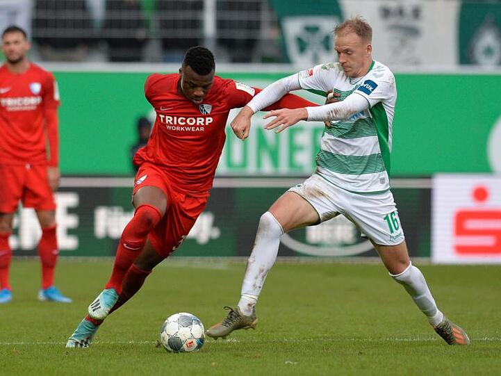 Harvard Nielsen von der SpVgg Greuther Fürth kämpft gegen Bochums Armel Bella Kotchap (l) um den Ball.