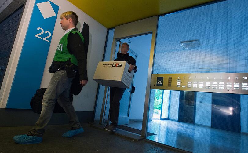 Ermittler des Staatsschutzes und der Polizei tragen am 25.06.2013 aus einem Haus im Olympiadorf im Norden von München (Bayern) Kartons mit Beweismaterial. In den frühen Morgenstunden wurde eine Wohnung in dem Objekte von Spezialeinsatzkommandos gestürmt und durchsucht. Technisches Gerät und Unterlagen seien nach Angaben der Bundesanwaltschaft sichergestellt worden.
