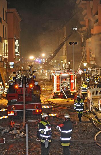 Feuer, Rauch, zerborstene Fenster - nach der Sprengung der Bombe hat die Feuerwehr viel zu tun: Umherfliegendes Stroh hatte Brände verursacht.