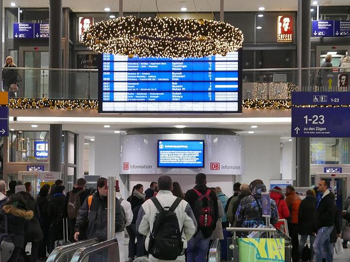 Reisende stehen im Nürnberger Hauptbahnhof.