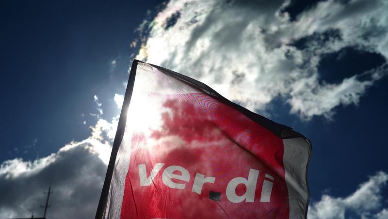 Eine Fahne von Verdi weht während einer Kundgebung. Foto: Ina Fassbender/dpa/Archivbild/Symbolbild