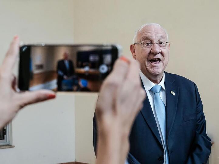 Eine Frau fotografiert Reuven Rivlin bei der Stimmabgabe mit dem Handy. Der Staatspräsident Präsident bestimmt nach der Wahl, wer den Auftrag zur Regierungsbildung erhält.