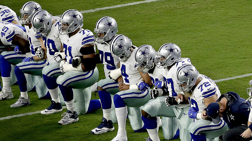 Die Dallas Cowboys knien auf dem Rasen nieder, bevor die US-Nationalhymne gespielt wird.