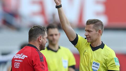 Schiedsrichter Tobias Welz (r) zeigt Paderborn-Trainer Baumgart (l) die erste Gelbe Karte.