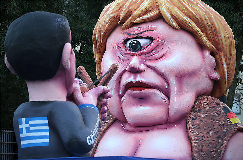Düsseldorf: Der Motivwagen zeigt den griechischen Ministerpräsidenten Alexis Tsipras, der die Bundeskanzlerin Angela Merkel mit einer Steinschleuder abschießt.