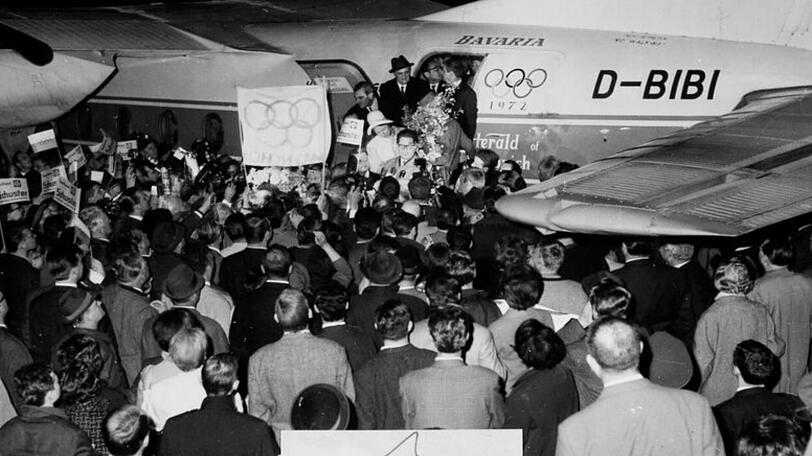 Und er bringt tatsächlich die Olympischen Spiele mit: Hans-Jochen Vogel bei seiner Rückkehr von der Vergabe am Flughafen Riem.