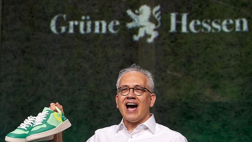 Tarek Al-Wazir erhält als Geschenk ein Paar Turnschuhe. Diese sollen an den ersten grünen Minister im hessischen Kabinett erinnern, der in Turnschuhen zur Vereidigung kam.