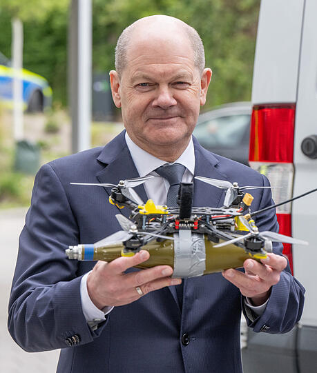 Bundeskanzler Olaf Scholz mit der Replik einer mit einem Sprengkopf bestückten Drohne, wie sie im Ukraine-Krieg zum Einsatz kommt.