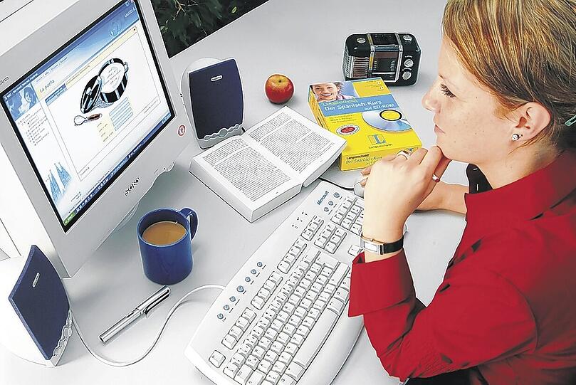 Eine Frau sitzt vor einem Computer. PC-Rückgang durch die Flut in Thailand.