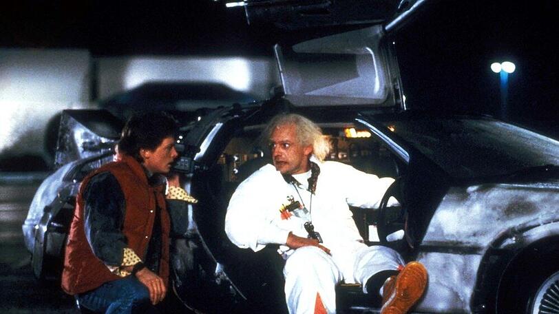 Marty (Michael J. Fox, l. ) und Doc (Christopher Lloyd) mit dem DeLorean in "Zurück in die Zukunft" (1985).