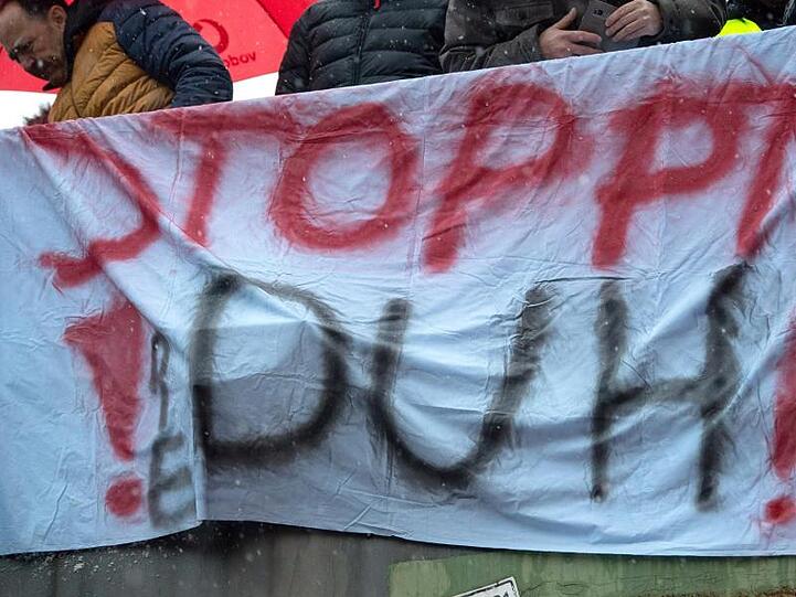 Ein Banner mit der Aufschrift "Stoppt DUH!" (Deutsche Umwelthilfe) hängt während einer Demonstration gegen das Dieselfahrverbot in Stuttgart an einer Brücke.