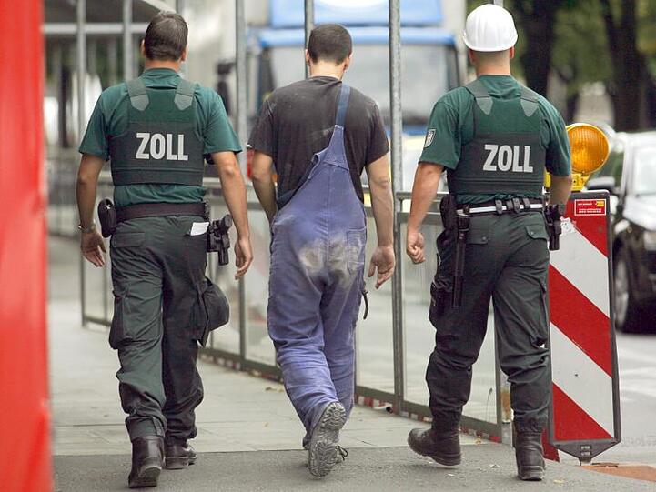 Zollbeamte bringen auf einer Baustelle im Berliner Stadtteil Mitte einen Arbeiter zur Befragung.