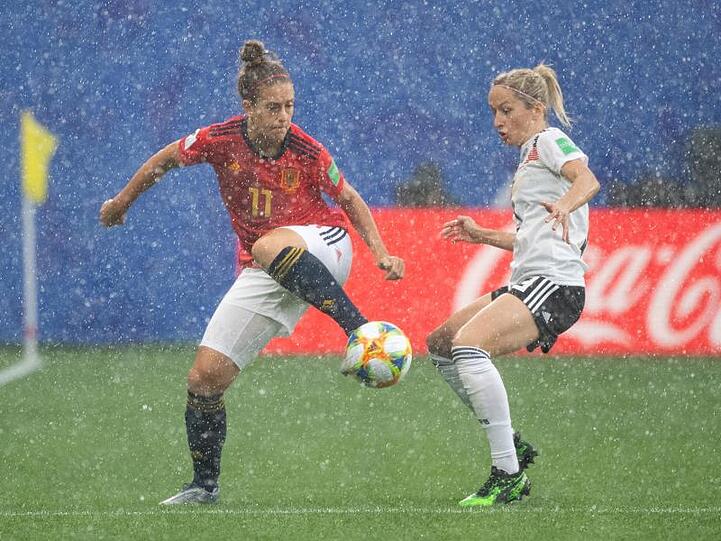Spaniens Alexia Putellas (l) kämpft im strömenden Regen mit Kathrin Hendrich um den Ball.