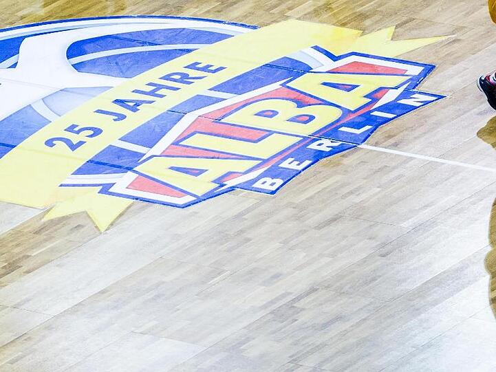 Ein Spieler von Alba Berlin läuft am Logo des Vereins vorbei. Foto: Lukas Schulze/Archivbild