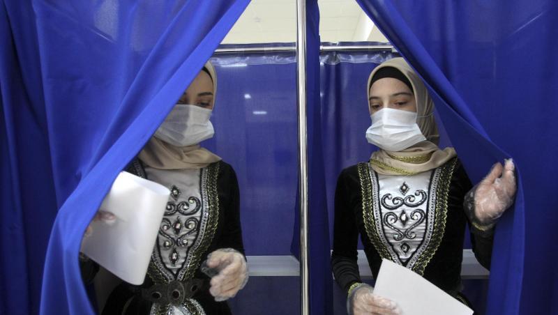 Frauen in tschetschenischer Nationaltracht verlassen eine Wahlkabine in Grosny. Bei der von Manipulationsvorwürfen überschatteten Wahl der neuen Staatsduma hat sich die Kremlpartei Geeintes Russland laut ersten Ergebnissen als stärkste Kraft behauptet.
