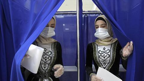 Frauen in tschetschenischer Nationaltracht verlassen eine Wahlkabine in Grosny. Bei der von Manipulationsvorwürfen überschatteten Wahl der neuen Staatsduma hat sich die Kremlpartei Geeintes Russland laut ersten Ergebnissen als stärkste Kraft behauptet.