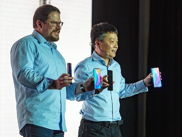 Xiaomi-Manager Xian Wang (r) und Christiano Amon vom Chipkonzern Qualcomm präsentieren das Xiaomi-Smartphone Mi Mix 3 5G beim Mobile World Congress in Barcelona.