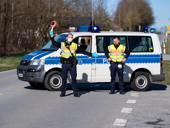 Polizisten stehen in der Nähe von Neuhaus am Inn an einer Kontrollstelle an der Grenze zu Österreich.