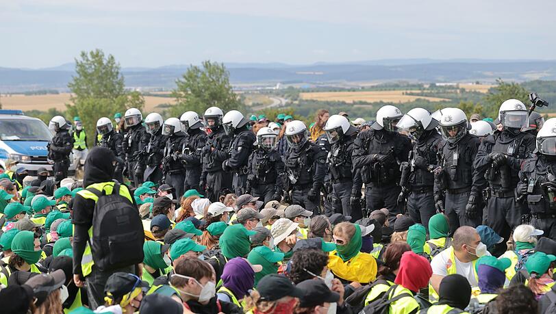 Eine Sitzblockade auf der Autobahn 71 - Polizisten umringen die Demonstranten.