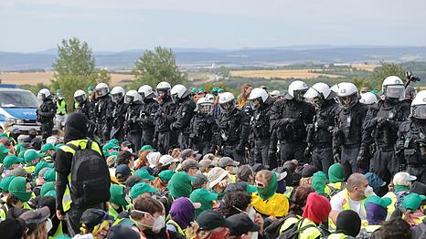 Eine Sitzblockade auf der Autobahn 71 - Polizisten umringen die Demonstranten.