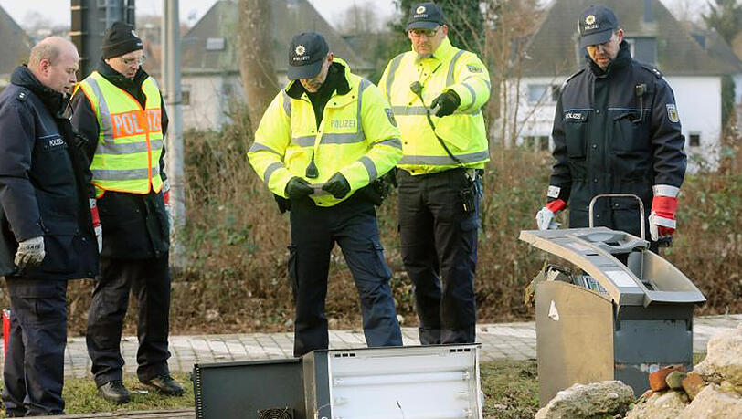 Polizisten sammelten Münzen und Scheine ein. Die Täter erbeuteten kein Geld. Polizisten sammelten Münzen und Scheine ein. Die Täter erbeuteten kein Geld.
