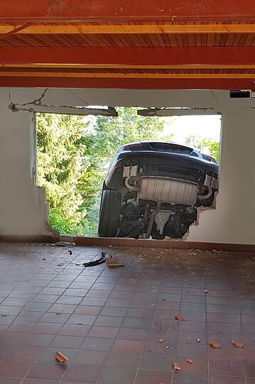Ein Mann hat mit seinem Porsche die Garagenwand durchbrochen und ist im Garten gelandet. Die Bilder vom Einsatz.