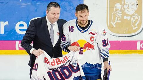 Münchens Yannic Seidenberg (r) und Christian Winkler halten ein Trikot mit der Aufschrift &bdquo;1000&ldquo;. Foto: Uwe Anspach/dpa