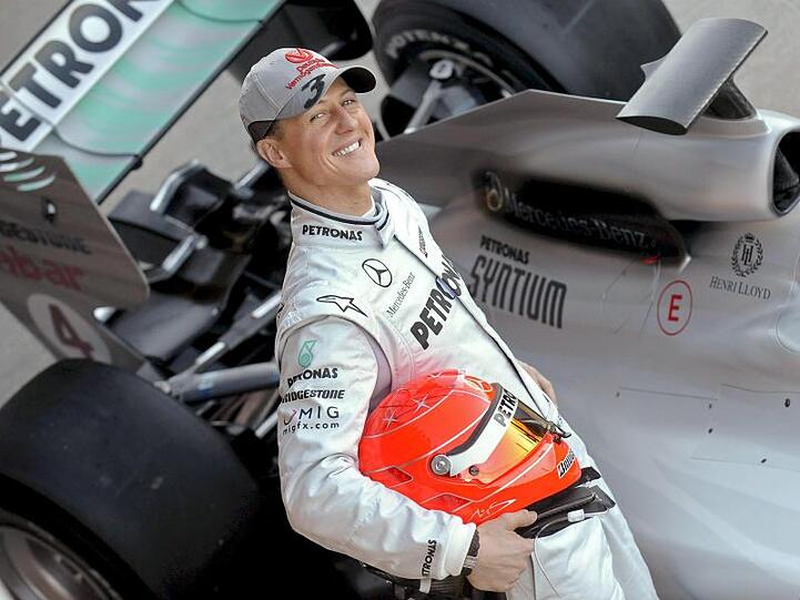 Der deutsche Formel-1-Pilot Michael Schumacher posiert 2010 neben seinem Mercedes-Rennwagen.