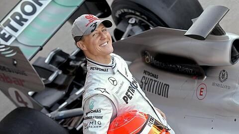 Der deutsche Formel-1-Pilot Michael Schumacher posiert 2010 neben seinem Mercedes-Rennwagen.