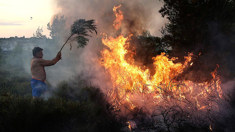 Ein Anwohner versucht in Kalamos einen Waldbrand zu löschen. Insgesamt 53 Waldbrände sind in Griechenland über das Wochenende verzeichnet worden.