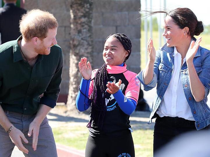 Prinz Harry und Herzogin Meghan mit einer Mitarbeiterin der Organisation "Waves for Change" am Monwabisi Beach.