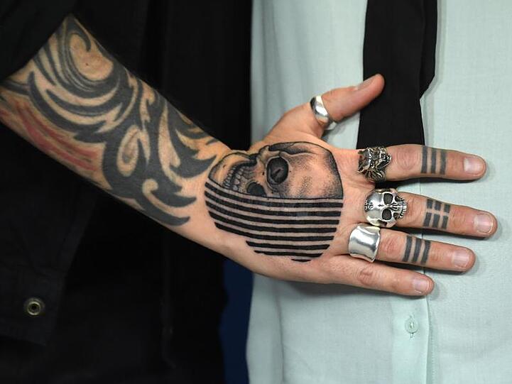 Der "Répertoire des villes disparues (Ghost Town Anthology)"-Regisseur zeigt seine Tattoos und Silberringe.