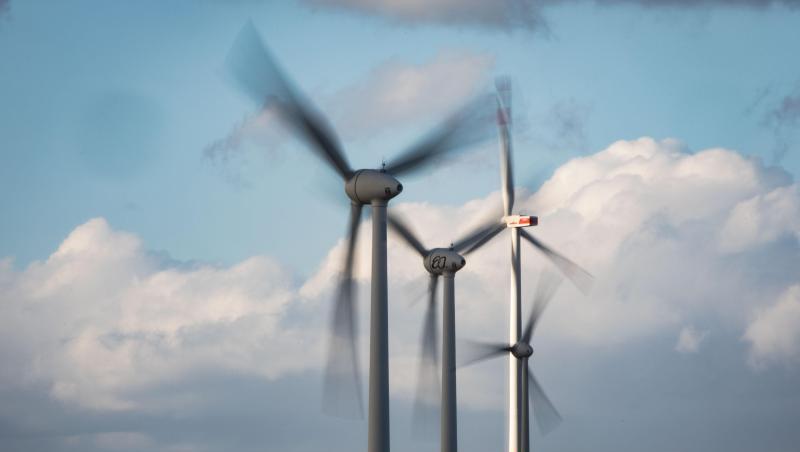 Windräder drehen sich auf einer Anhöhe in Rheinhessen.