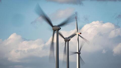 Windräder drehen sich auf einer Anhöhe in Rheinhessen.