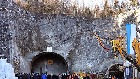 Arbeiter und Gäste stehen vor dem zukünftigen Nordportal des Kramertunnels.