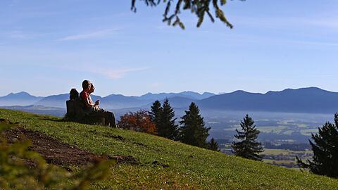 Zwei Wanderer pausieren auf dem Auerberg bei Bernbeuren.