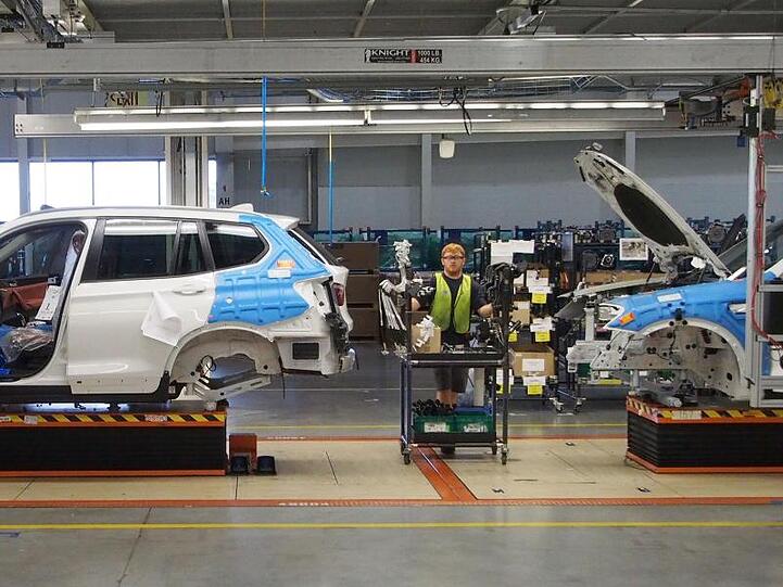 Mitarbeiter des BMW-Werkes in Spartanburg arbeiten an einem SUV. Foto: Daniel Schnettler/Archivbild