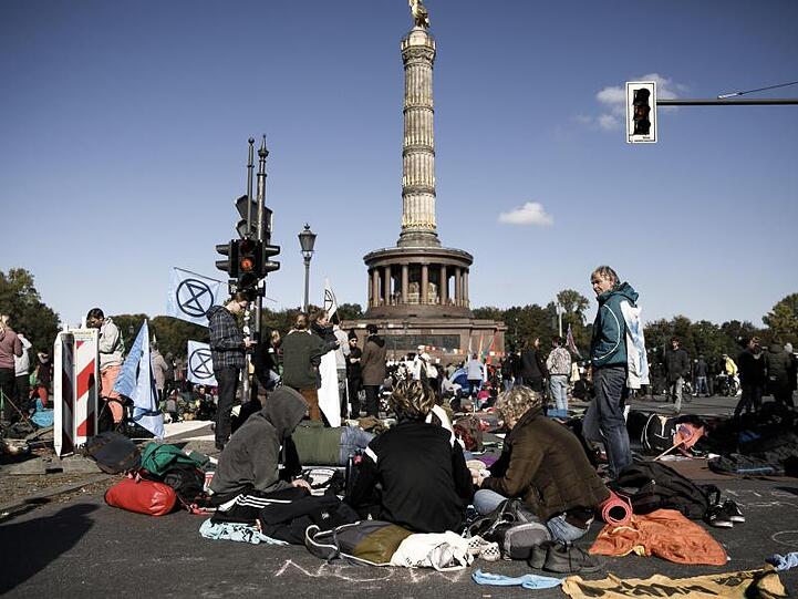 Aktivisten der Klimabewegung Extinction Rebellion besetzen die Fahrbahn am Großen Stern um die Siegessäule. Foto: Carsten Koall/dpa