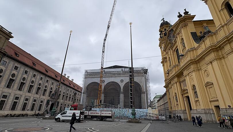 Mit einem Baukran wird die provisorische Dachabdeckung auf der Feldherrnhalle kompletiert.